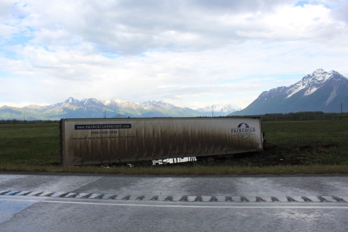 Semi sunk to it's axles in the marsh next to the highway